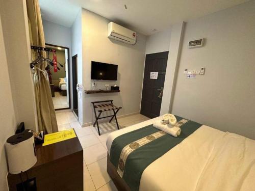 a hotel room with a bed and a television at R Hotel Langkawi in Kuah