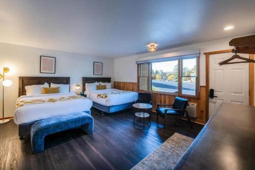 レイクプラシッドにあるTown House Lodgeのベッド2台と窓が備わるホテルルームです。