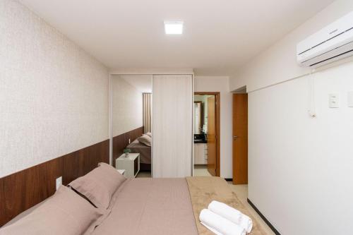 um quarto com uma cama e um espelho em Ap 2 quartos-Setor Bueno-Ed Pontal Premium-PPB1206 em Goiânia