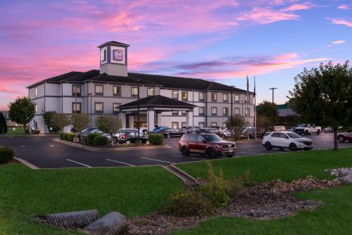 a large building with a clock tower in a parking lot at Sleep Inn & Suites Cave City in Cave City