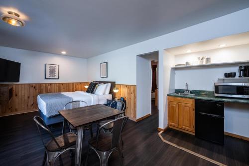 a room with a bed and a kitchen with a table at Town House Lodge in Lake Placid