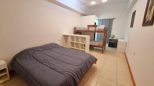 um pequeno quarto com uma cama e uma cadeira em Hostel S & J Mendoza em Guaymallen