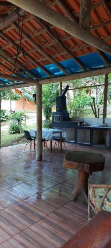 a covered patio with a stove and a table at Chalé Recanto Das Saíras em Paraty in Paraty