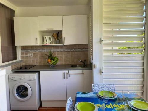 une cuisine avec un évier et une machine à laver dans l'établissement Studio cosy à Saint-François - 21 m² avec balcon et piscine, à Saint-François