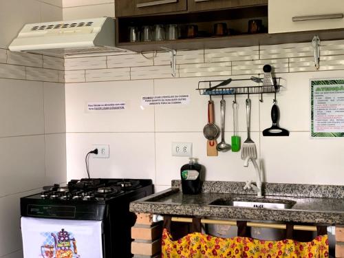 a kitchen with a stove and a counter top at Hostel Vento Leste in Bombinhas