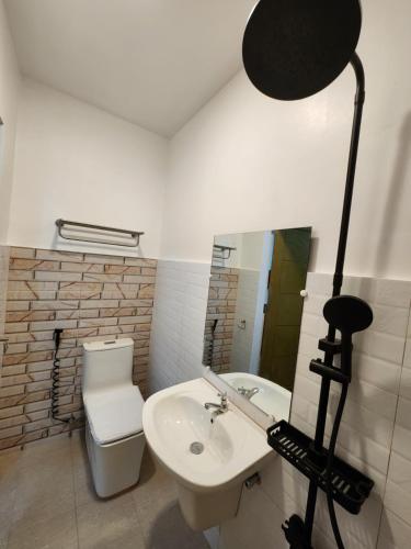 ein Badezimmer mit einem Waschbecken, einem Spiegel und einer Kamera in der Unterkunft E&C Tourist Inn in Dumaguete