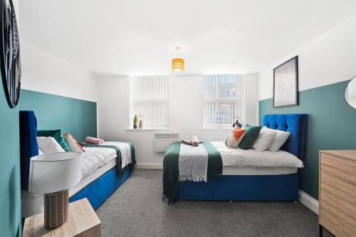 duas camas num quarto com azul e branco em Boutique Nottingham Abode - Sleeps 6 em Nottingham