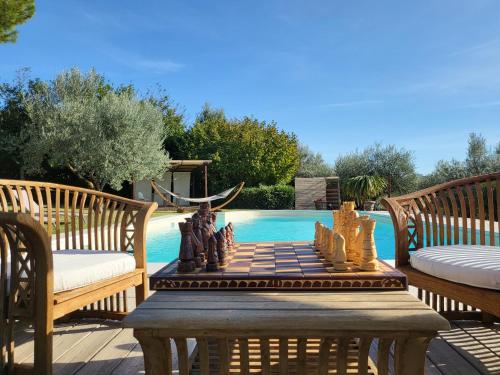 una scacchiera su un tavolo accanto a una piscina di Villa with Pool and Countryside View a Montefalco