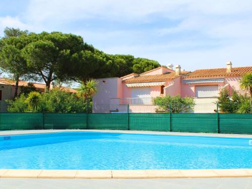 une piscine bleue devant une maison dans l'établissement Appartement T2 climatisé avec mezzanine, piscine et parking, proche plage - Agde - FR-1-607-119, au Cap d'Agde
