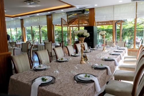 a long dining room with a long table and chairs at Buna Park Hotel in Shkodër
