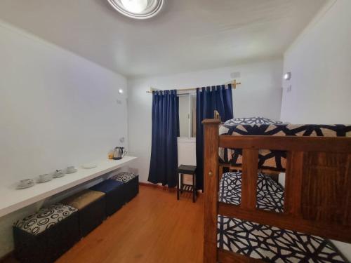 um quarto com um beliche e um sofá em Hostel S & J Mendoza em Guaymallen