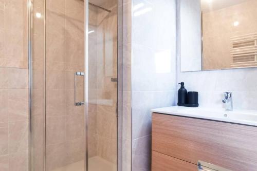 La salle de bains est pourvue d'une douche avec une porte en verre. dans l'établissement STUDIO COSY - Télécabines à 50 M - SKI IN SKI OUT, à Saint-Gervais-les-Bains