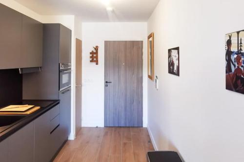 une cuisine avec un comptoir et un couloir avec une porte dans l'établissement STUDIO COSY - Télécabines à 50 M - SKI IN SKI OUT, à Saint-Gervais-les-Bains