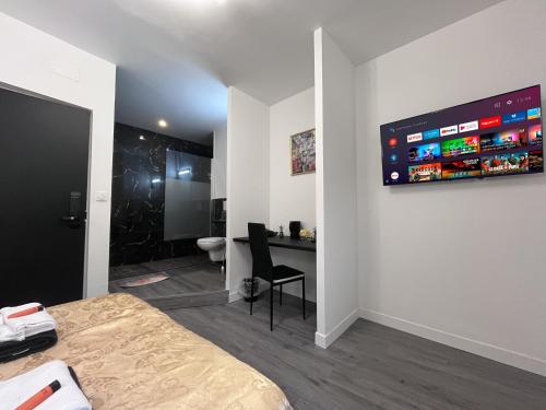 ナルボンヌにあるCosy Centre Ville Narbonneのベッドルーム1室(ベッド1台、デスク、壁のモニター付)