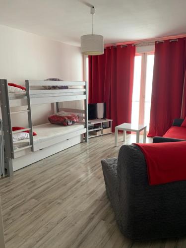 a bedroom with two bunk beds with red curtains at Studio La Mongie in La Mongie
