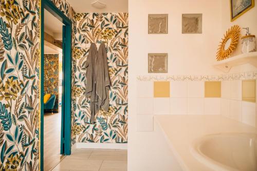 baño con bañera y pared de azulejos en Suite Maëlle _ Résidence Isaelle, en Bray-Dunes