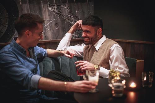 two men sitting at a table with a glass of wine at The Circus Hotel in Berlin