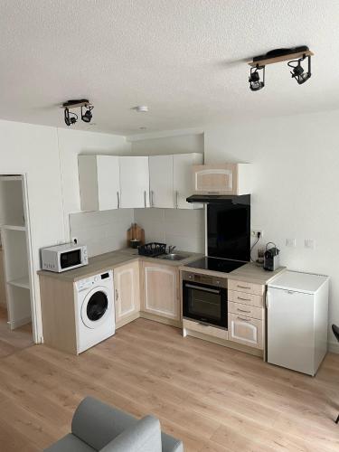 une cuisine avec une cuisinière et un micro-ondes dans l'établissement Appart avec chambre lumineux et chaleureux, au Boulou