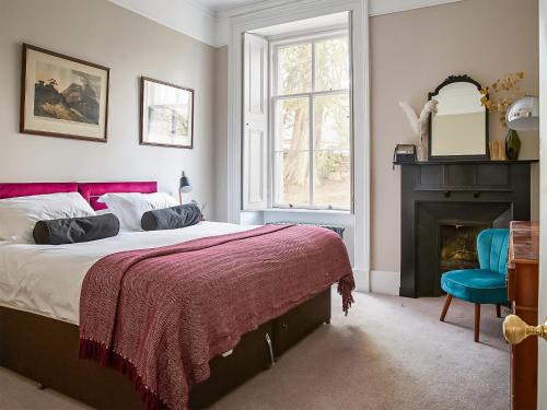 um quarto com uma cama grande e uma lareira em Coillemore House em Balmacara