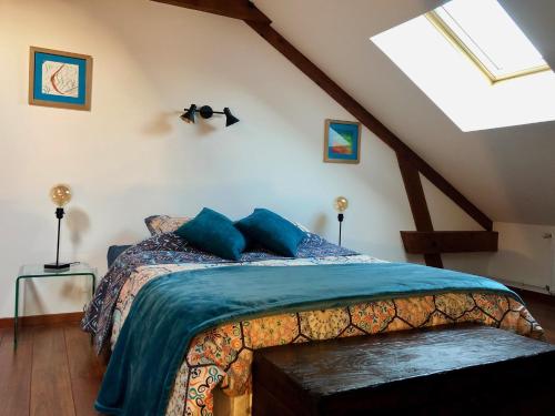 a bedroom with a bed with a blue comforter at Le jardin des Vérottes in Beaune
