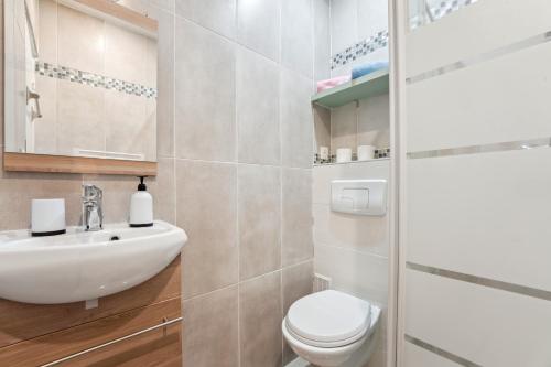 une salle de bain avec des toilettes blanches et un lavabo dans l'établissement Budget appart avec parking au centre-ville, à Charleville-Mézières