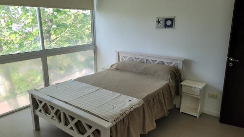 1 dormitorio con cama y ventana grande en DeptosNaviMdP en Mar del Plata