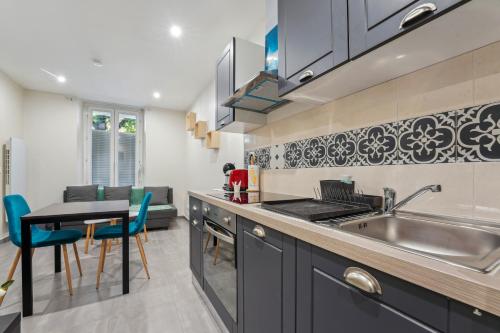 - une cuisine avec un évier et une table dans l'établissement Budget appart avec parking au centre-ville, à Charleville-Mézières