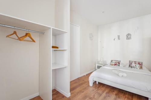 a white bedroom with a bed and a closet at Appartement budget avec parking au centre-ville in Charleville-Mézières