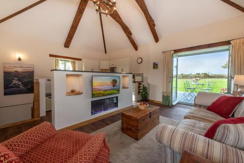 a living room with a large flat screen tv at 18th century renovated barn in beautiful Devon countryside in Broadwoodwidger