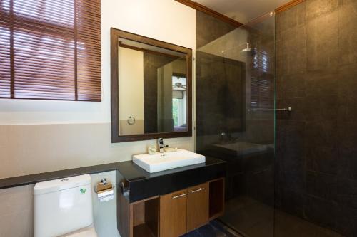 y baño con lavabo, aseo y espejo. en Thai-Balinese Boutique Villa Alex in Rawai, 3BR, Private Pool en Rawai Beach