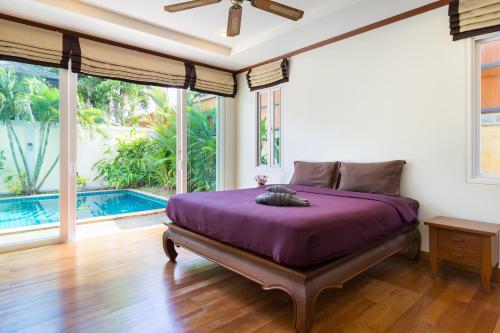 1 dormitorio con cama morada en una habitación con piscina en Thai-Balinese Boutique Villa Alex in Rawai, 3BR, Private Pool en Rawai Beach