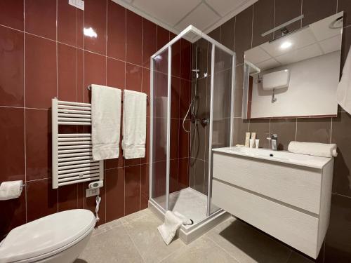 uma casa de banho com um WC, um chuveiro e um lavatório. em Motel Vespucci em Guasticce