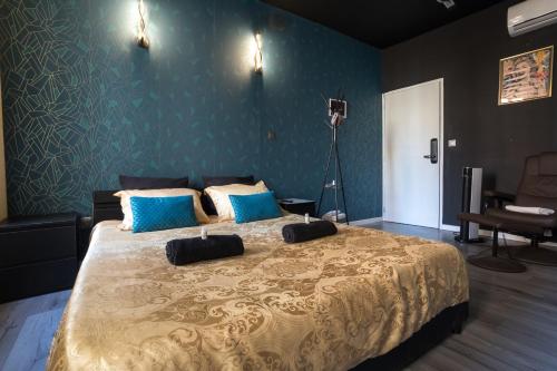 a bedroom with a large bed with blue walls at Baignoire Centre Ville Narbonne in Narbonne