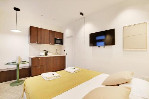 une chambre avec un grand lit et une cuisine dans l'établissement Saint Ambroise Cosy suit 2P 1BDR, à Paris