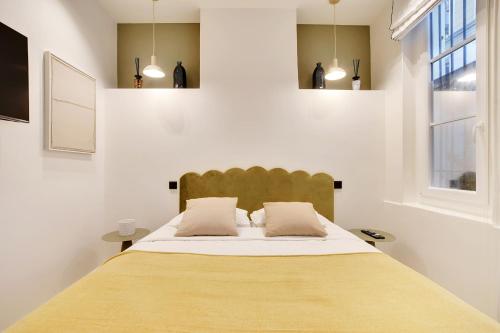 une chambre avec un grand lit avec deux oreillers dans l'établissement Saint Ambroise Cosy suit 2P 1BDR, à Paris