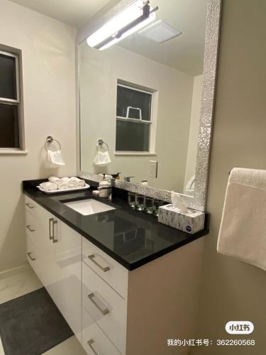 La salle de bains est pourvue d'un lavabo et d'un miroir. dans l'établissement 佳佳便利民宿B, à Vancouver