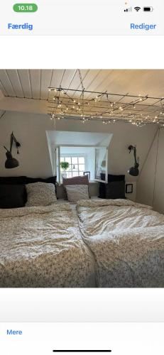 a bedroom with a large bed with lights above it at Bondehus in Holeby