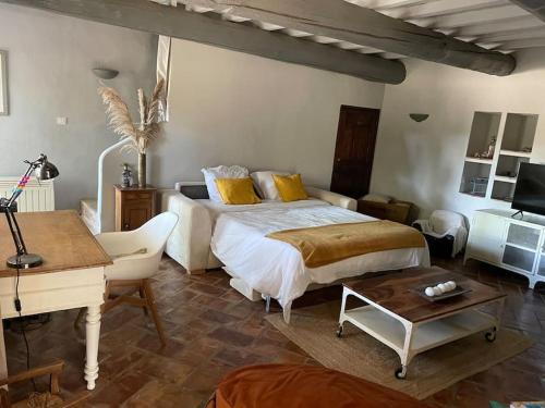 1 dormitorio con cama, escritorio y piano en Mas de Clary - propriété de caractère avec PISCINE, en Roquemaure