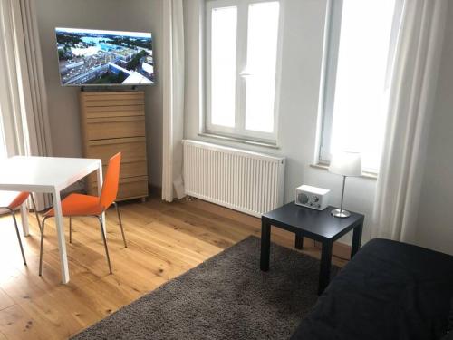 un soggiorno con tavolo e TV a parete di Wohnung 3 Söflingen a Ulma