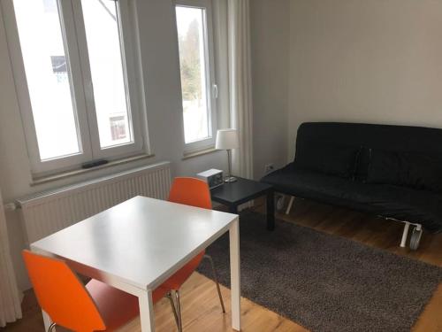 un soggiorno con tavolo bianco e divano nero di Wohnung 3 Söflingen a Ulma