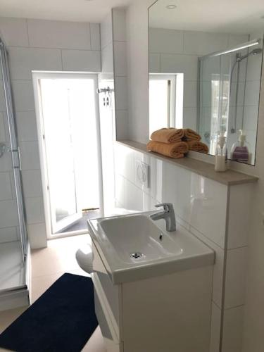 a white bathroom with a sink and a mirror at Wohnung 3 Söflingen in Ulm
