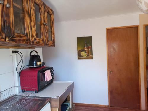 a kitchen with a red microwave on a table at Cabaña valle de elqui horcon Encantó del pimiento in Horcon