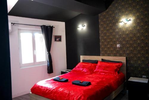 um quarto com uma cama vermelha com almofadas vermelhas e uma janela em Studio Baignoire centre ville em Narbona