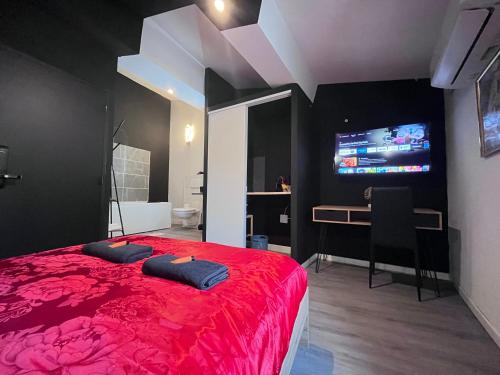 ナルボンヌにあるStudio Baignoire centre villeのベッドルーム(赤いベッド1台、デスク、テレビ付)