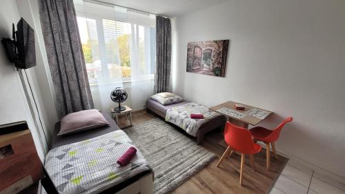 a small room with a bed and a table and a window at Appartement Bahnhof in Mainz