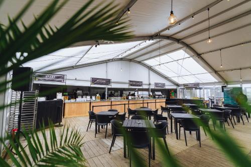 a restaurant with tables and chairs and a bar at Global-Tickets Village Spa-Francorchamps in Francorchamps