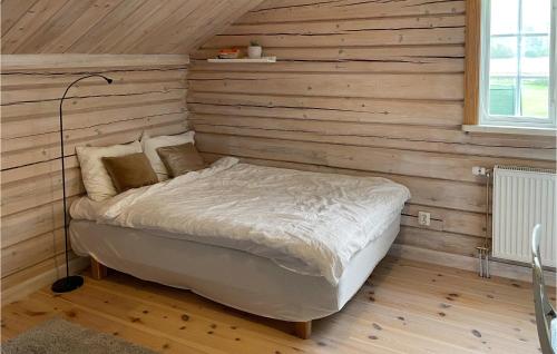 a bed in a room with a wooden wall at Lovely Home In Mora With Sauna in Mora