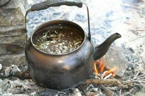 a tea kettle sitting on top of a fire at Dana Rose camp outdoor camping in Dana