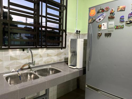 クアンタンにあるHomestay Kuantan Pantai Batu Hitam No14 L4のシンクと冷蔵庫付きのキッチン