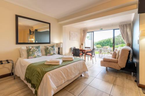 a bedroom with a bed and a table and chairs at 6 On Protea in Knysna